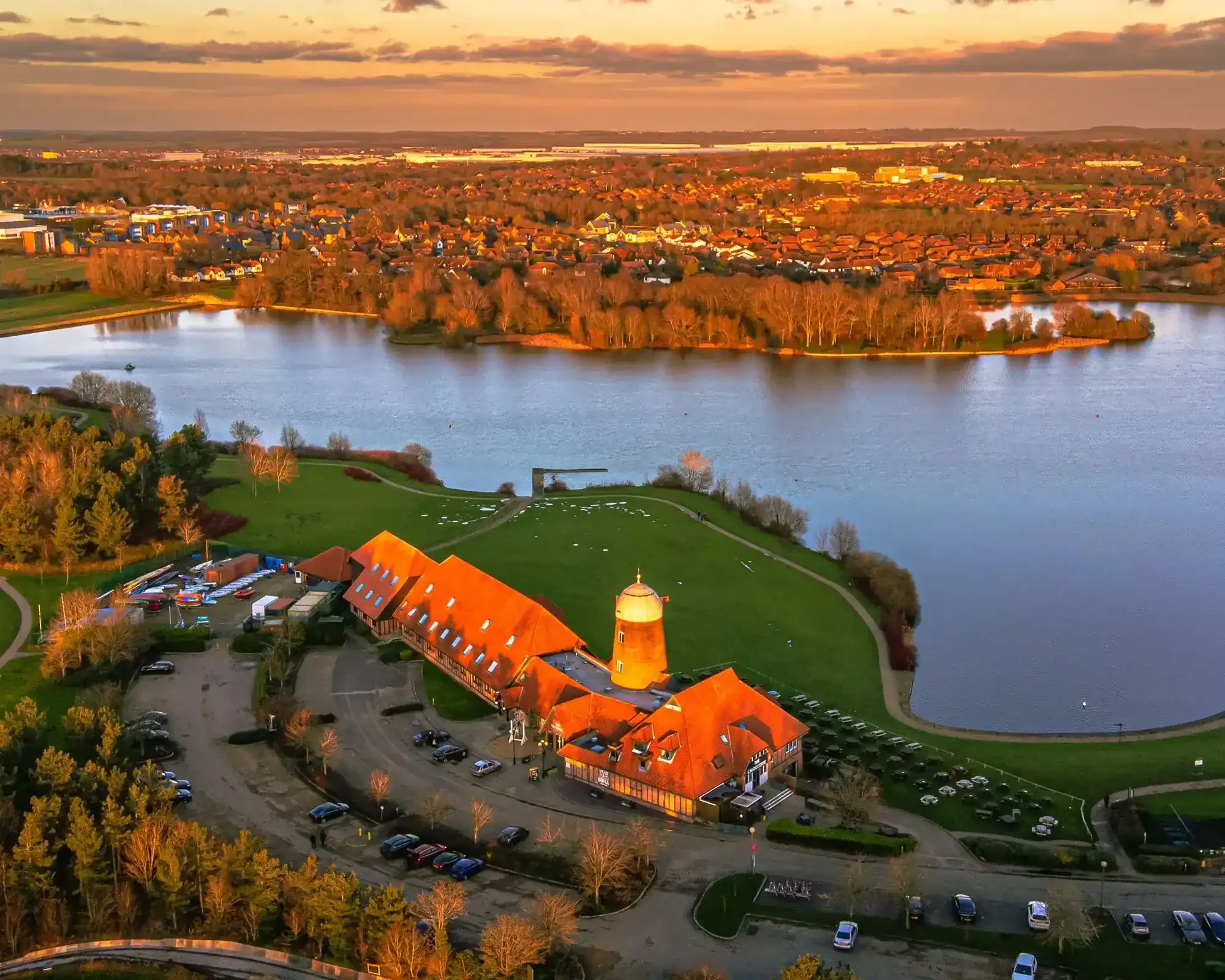 Aerial view of Willen Lake and windmill in Milton Keynes at sunset, home to our conveyancing solicitors