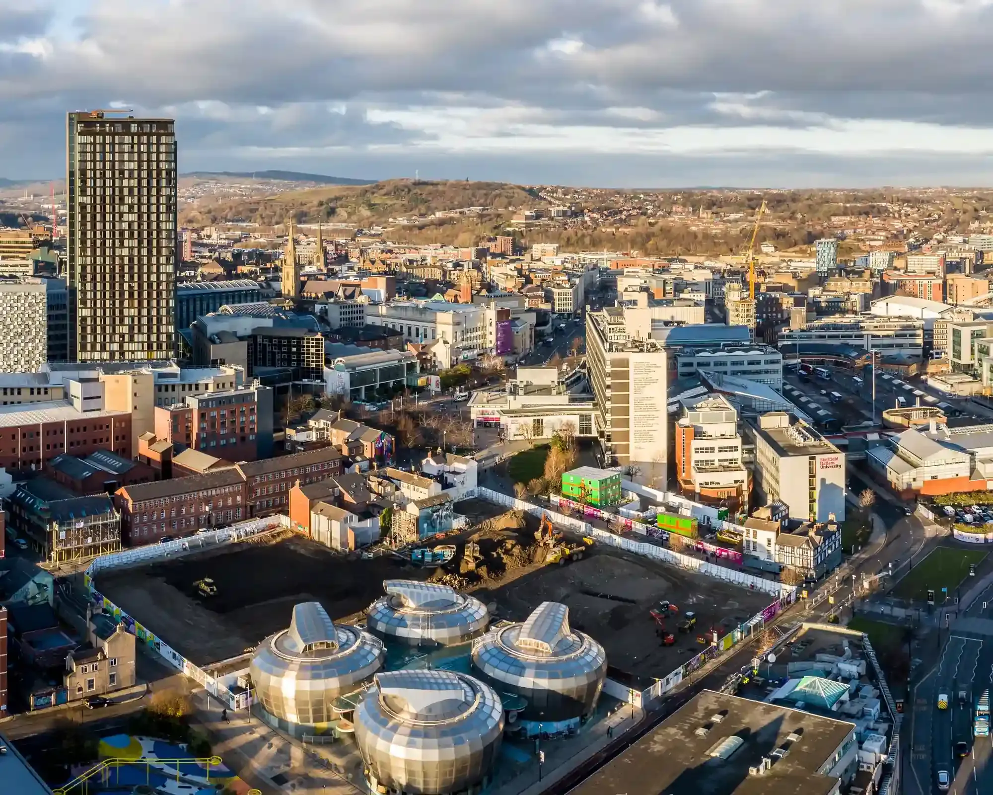 Aerial view of Sheffield city centre, featuring high-rise buildings and the surrounding hills, home to our conveyancing solicitors