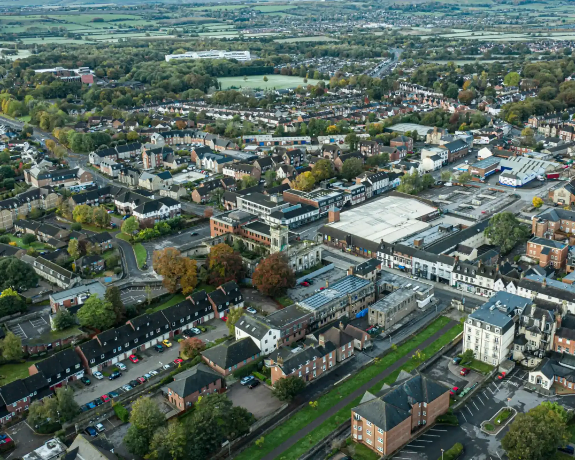 Aerial view of Swindon Old Town in autumn, with the clock tower of the old Corn Exchange among the rooftops and countryside beyond.